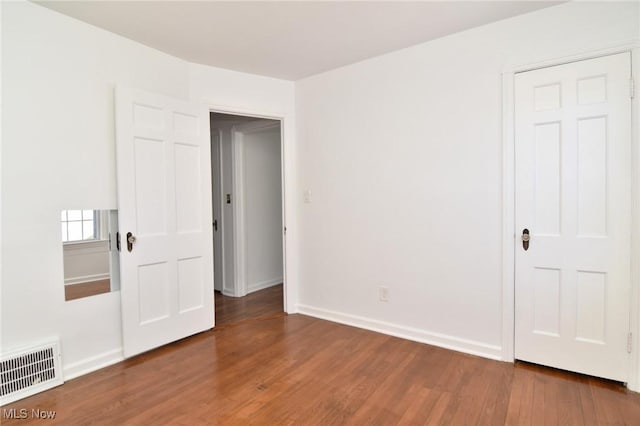 empty room with dark hardwood / wood-style flooring