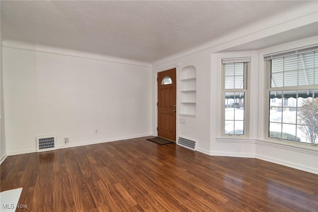 foyer entrance featuring dark hardwood / wood-style floors and a textured ceiling