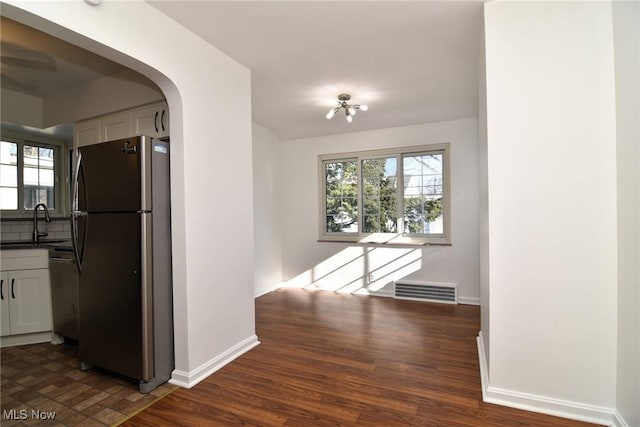 hallway with sink, plenty of natural light, and dark hardwood / wood-style floors