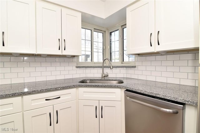 kitchen featuring sink, light stone counters, tasteful backsplash, stainless steel dishwasher, and white cabinets