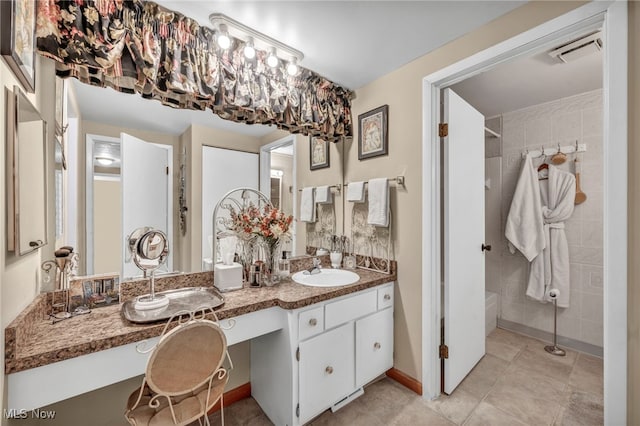 bathroom featuring vanity, tile patterned flooring, and a shower