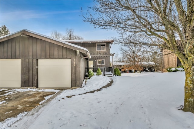 view of snow covered exterior featuring a garage