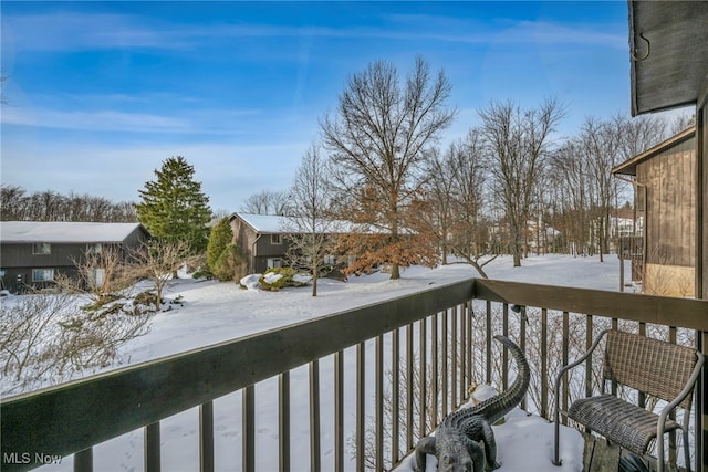 view of snow covered back of property