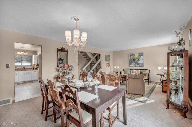 carpeted dining room featuring sink and a notable chandelier