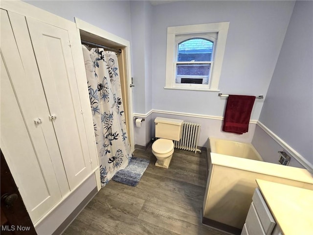 bathroom featuring hardwood / wood-style flooring, vanity, toilet, and radiator heating unit