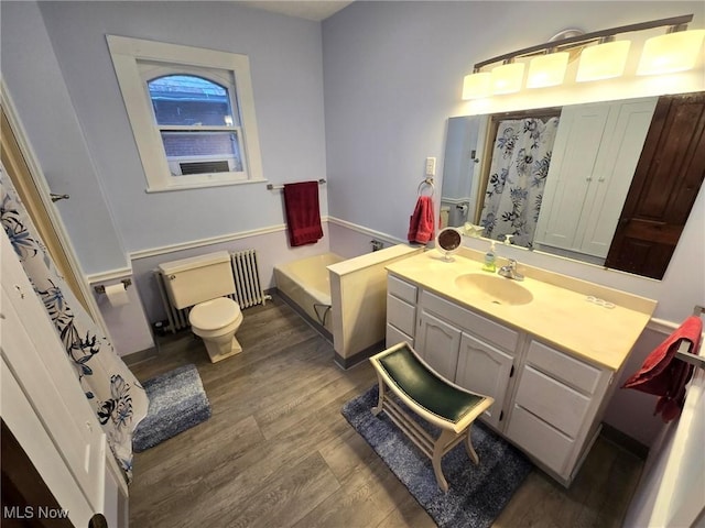 full bathroom with toilet, separate shower and tub, radiator heating unit, vanity, and hardwood / wood-style floors