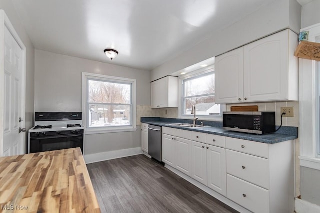 kitchen featuring dark hardwood / wood-style floors, butcher block counters, sink, white cabinets, and stainless steel appliances