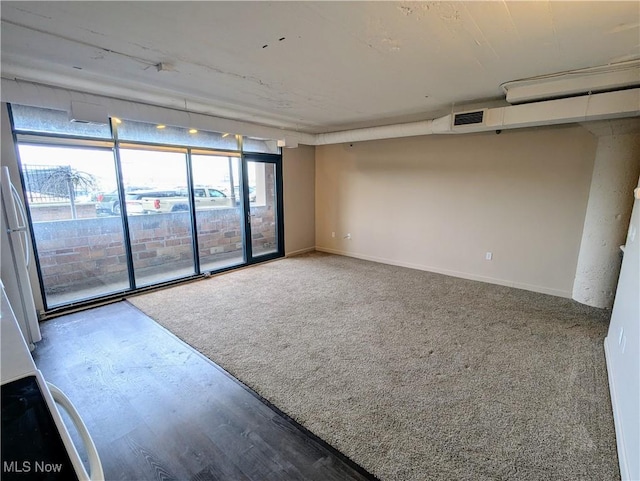 carpeted empty room featuring expansive windows