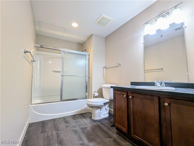 full bathroom with vanity, hardwood / wood-style floors, combined bath / shower with glass door, and toilet