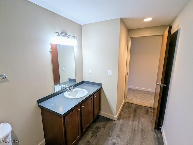 bathroom featuring vanity, toilet, and hardwood / wood-style floors