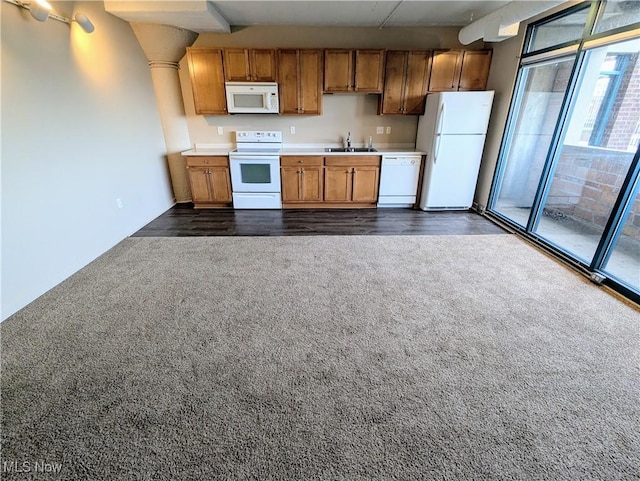 kitchen featuring dark carpet, sink, and white appliances