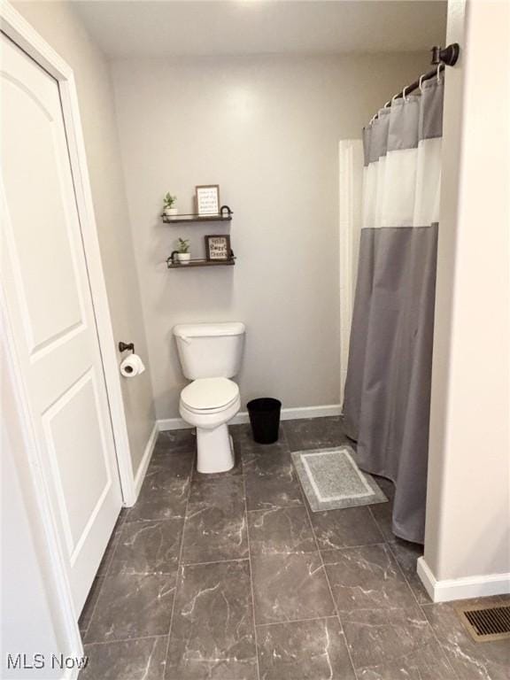 bathroom with a shower with curtain and toilet