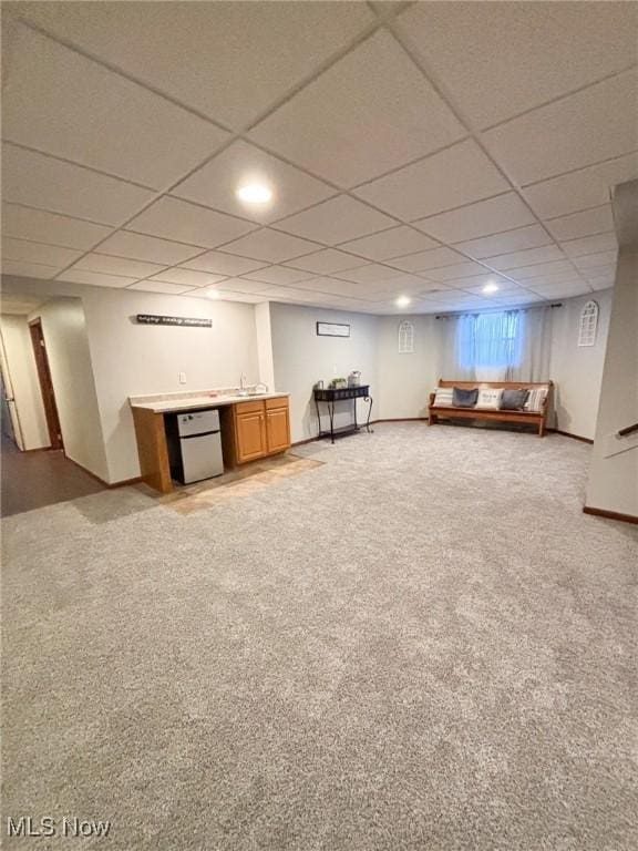 basement featuring bar, carpet, and a paneled ceiling