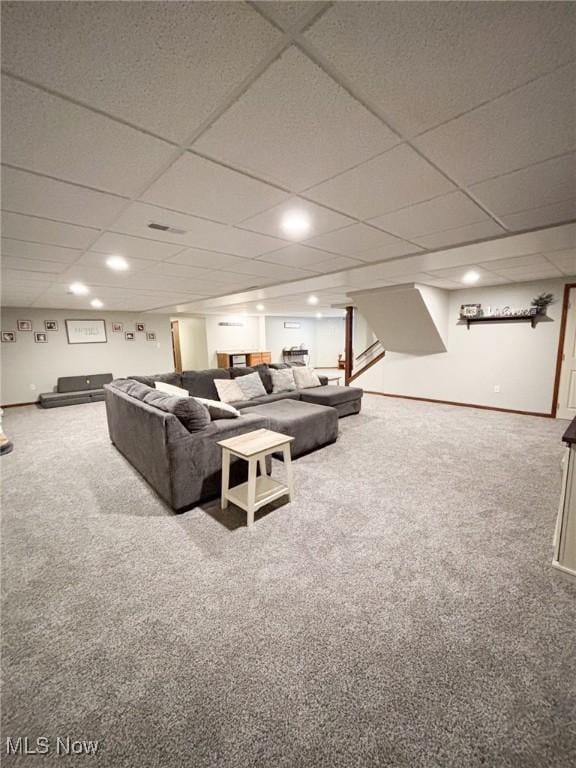 carpeted living room featuring a drop ceiling