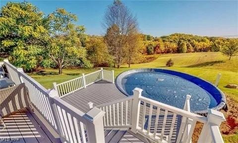 view of swimming pool with a lawn and a deck