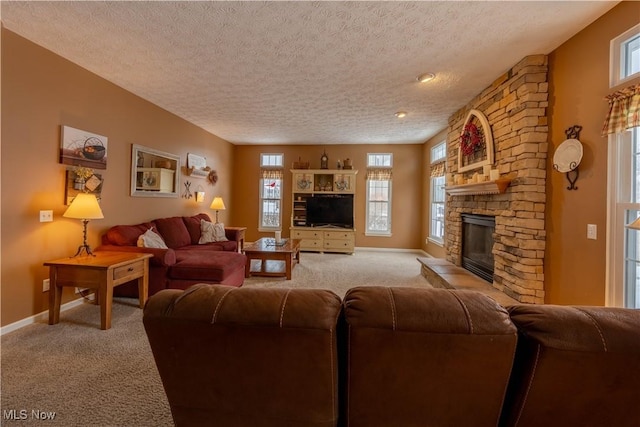 carpeted living room featuring a stone fireplace and a textured ceiling