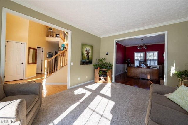 living room with ornamental molding, a chandelier, wood-type flooring, and a textured ceiling