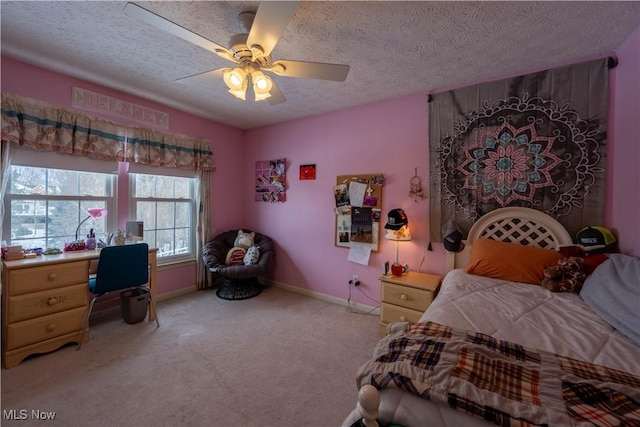 bedroom with ceiling fan, light colored carpet, and a textured ceiling