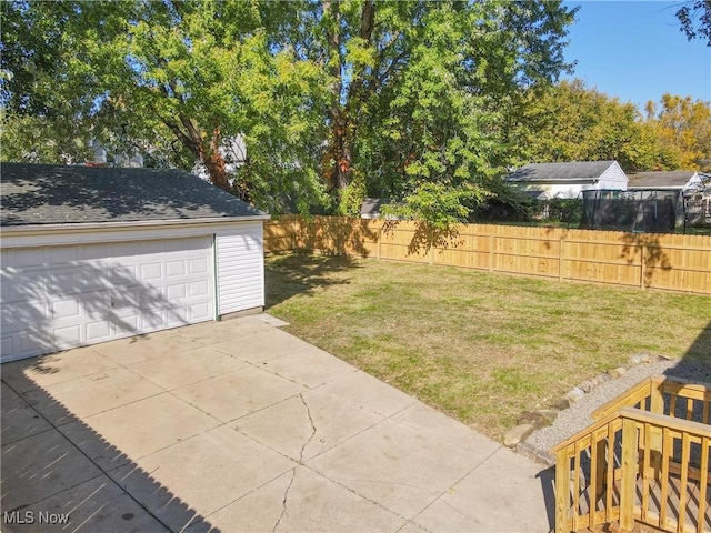 view of yard with a garage and an outbuilding