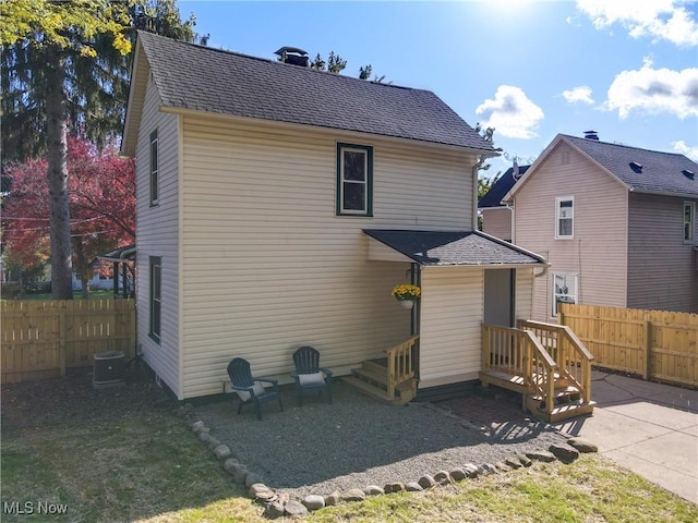 rear view of house featuring central AC unit