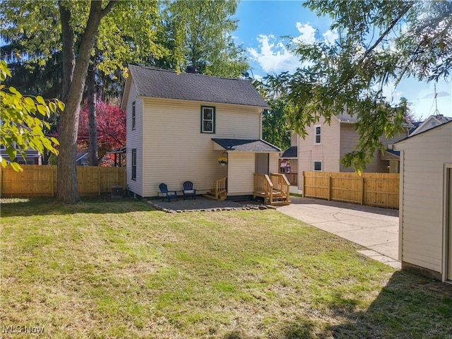 back of house with a patio area, a lawn, and central air condition unit