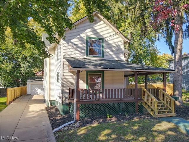 view of front of property with a garage, an outdoor structure, and covered porch