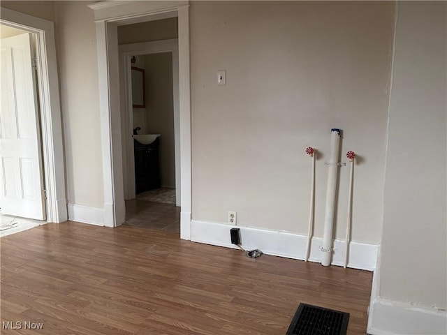 clothes washing area with sink and hardwood / wood-style floors