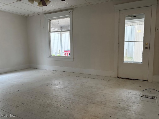 unfurnished room with a paneled ceiling, ceiling fan, and light hardwood / wood-style flooring