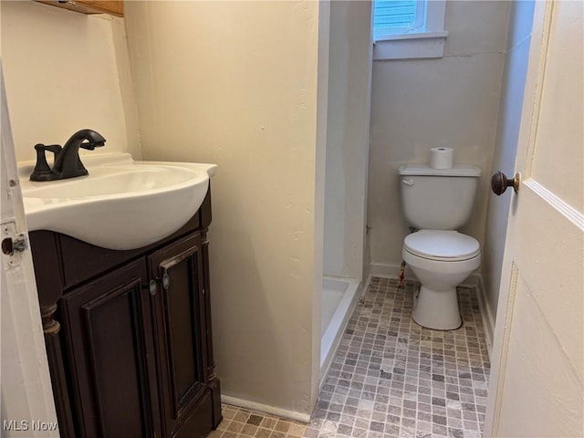 bathroom featuring vanity, a shower, and toilet