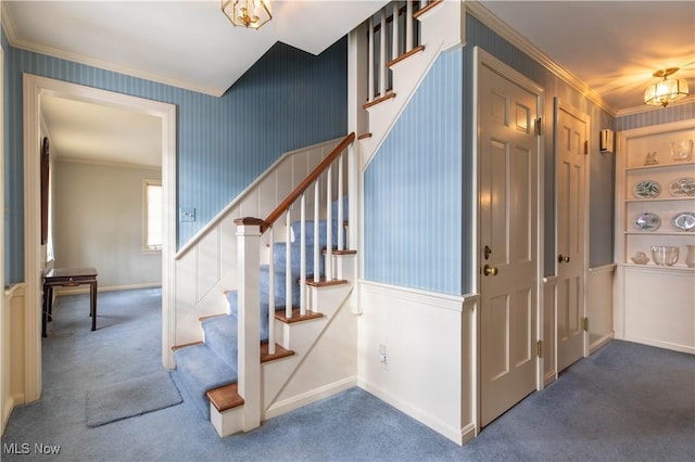 staircase with ornamental molding and carpet flooring