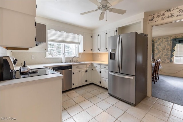 kitchen with sink, white cabinetry, ceiling fan, light colored carpet, and stainless steel appliances