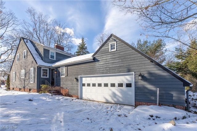 view of snowy exterior with a garage