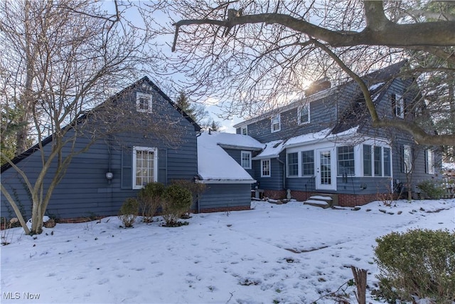 view of snow covered back of property