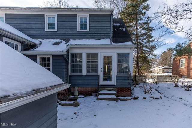 view of snow covered back of property