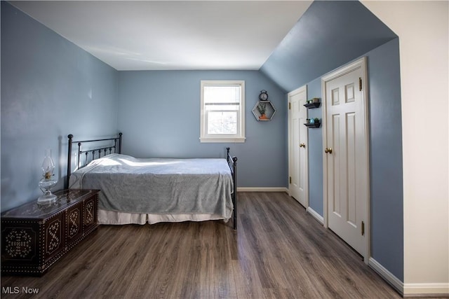 bedroom featuring lofted ceiling and dark hardwood / wood-style floors