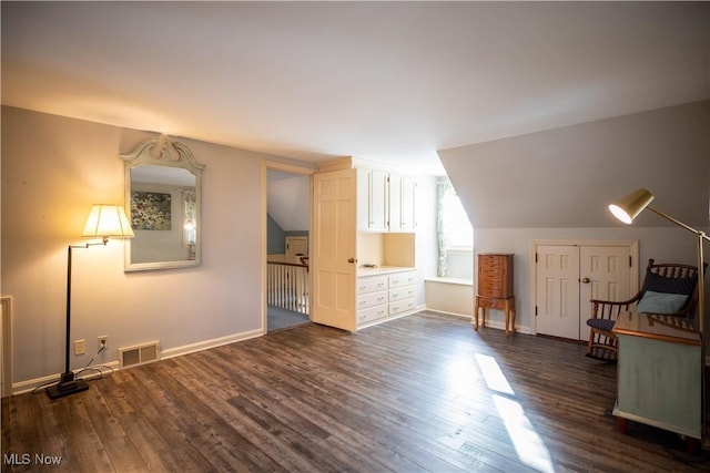 bonus room with dark hardwood / wood-style flooring and vaulted ceiling