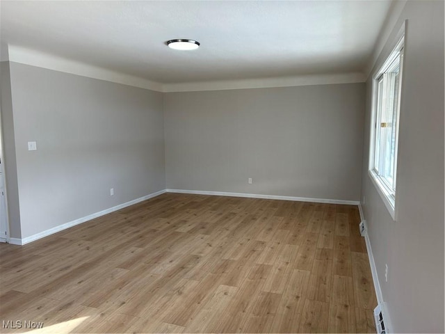 unfurnished room with crown molding and light wood-type flooring