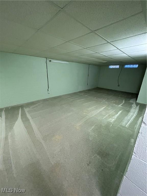 basement featuring carpet floors and a drop ceiling