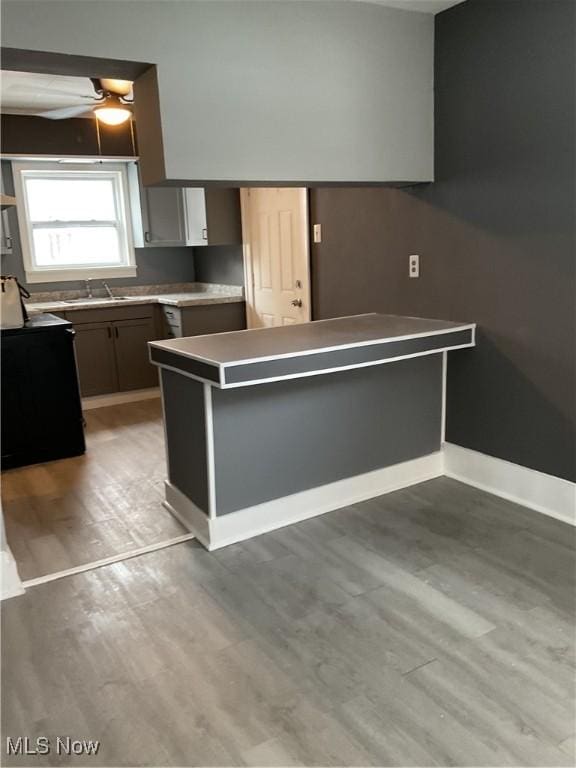 kitchen with sink, light hardwood / wood-style flooring, gray cabinets, ceiling fan, and kitchen peninsula