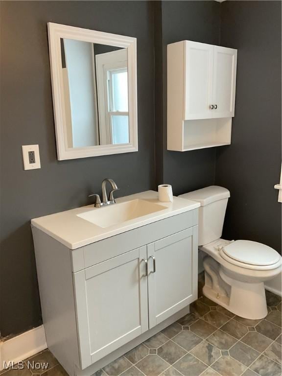 bathroom featuring vanity, tile patterned floors, and toilet