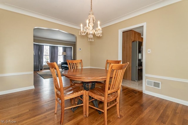 dining room with dark hardwood / wood-style flooring and ornamental molding