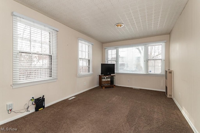 unfurnished living room featuring dark colored carpet