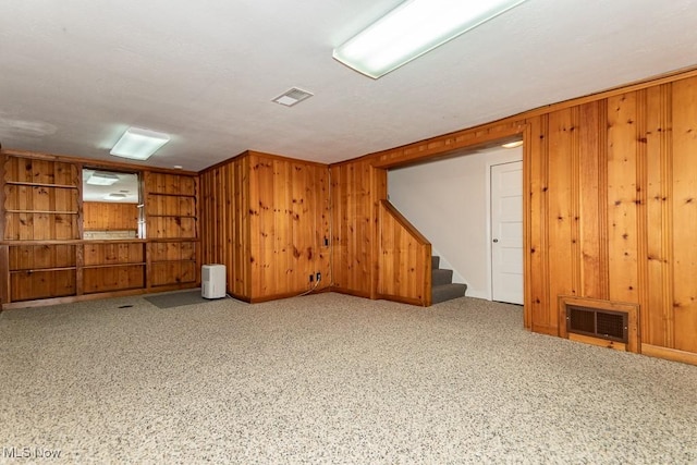 basement featuring wooden walls and carpet floors