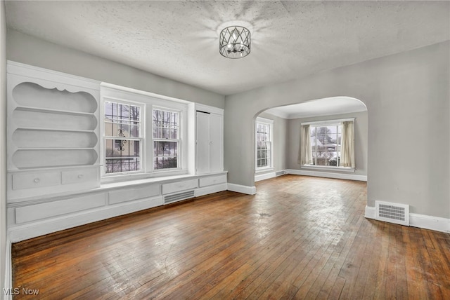 unfurnished living room featuring wood-type flooring and a textured ceiling