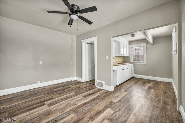 unfurnished living room featuring ceiling fan, dark hardwood / wood-style flooring, and sink