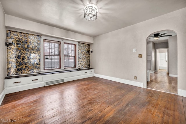 empty room with dark hardwood / wood-style floors and ceiling fan