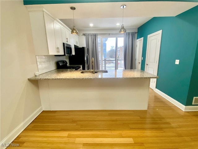 kitchen with sink, white cabinetry, hanging light fixtures, kitchen peninsula, and stainless steel appliances