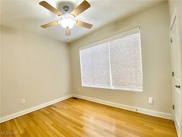 spare room featuring a wealth of natural light, light hardwood / wood-style flooring, and ceiling fan