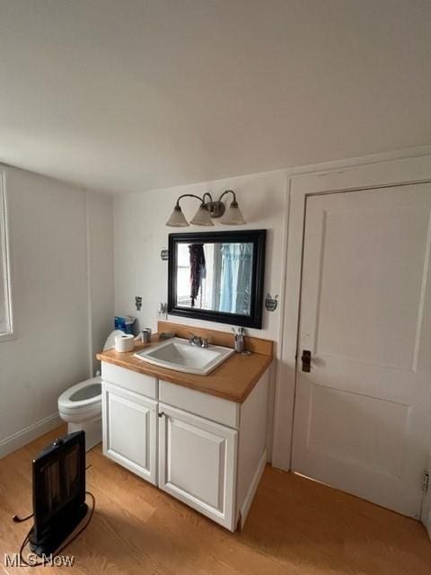 bathroom with vanity, toilet, and hardwood / wood-style floors