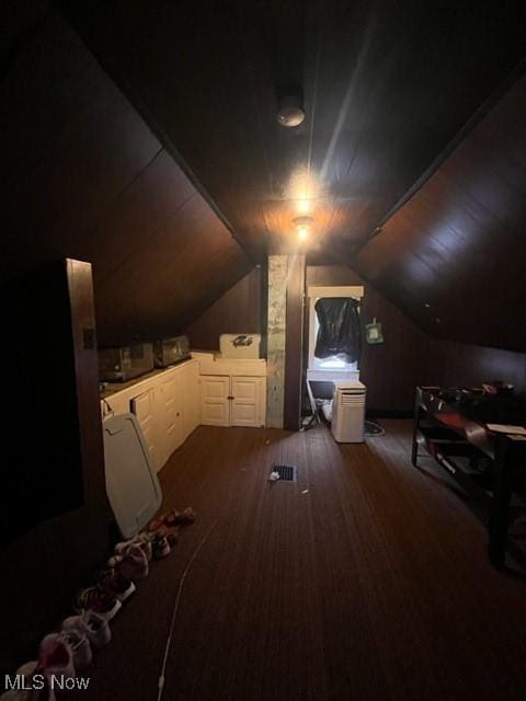 additional living space featuring lofted ceiling and dark hardwood / wood-style flooring